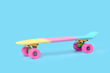 Side view of pastel neon rainbow colored Penny board skateboard isolated on solid blue background....