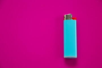 Gas lighter blue on a purple background. Close-up surface for your design. Empty gas plastic lighter mockup element. Close-up shot, top view.