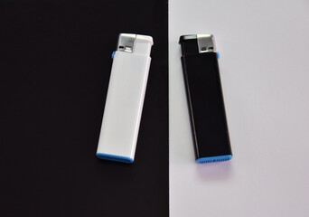 Flat lay and copy space. At the junction of the black and white background lies a black and white lighter. The concept of conservatism and minimalism. Classic colors in product advertisements