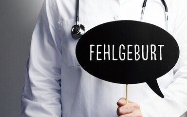 Fehlgeburt. Arzt mit Stethoskop hält Sprechblase in Hand. Text steht im Schild. Gesundheitswesen,...