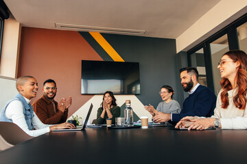 Successful businesspeople applauding their colleague