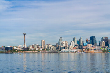 Fototapeta na wymiar Waterfront Seattle skyline with iconic view observation tower called Space Needle. Skyscrapers of financial downtown at day time, Washington, USA. A vibrant business neighborhood