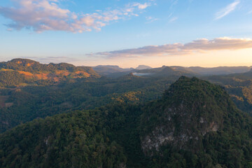 Fototapeta na wymiar Aerial top view of forest trees and green mountain hills. Nature landscape background, Thailand.
