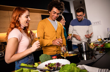 Group of friends preparing vegetarian meal in a kitchen at home.