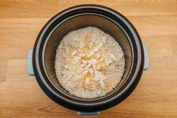white rice cooking in electric rice cooker with Turmeric, Curcumin, salt, onion and pepper.Muscle man meal. Arabic, Japanes, Korean, Chinese Food
