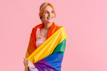 White excited woman screaming while posing with rainbow flag