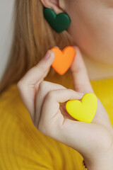 Teenage girl chooses jewelry earrings. Heart shaped earrings. St. Valentine's Day. High quality photo