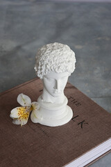 Plaster sculpture of a young guy with flowers