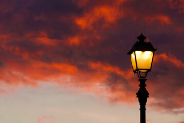 Fototapeta na wymiar Old fashioned street lamp against beautiful sunset sky and colorful clouds (with copy space)