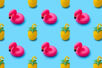 Fotobehang Summer pattern of toy pineapples and float flamingo inflatable toy on bright blue background © iwavephoto