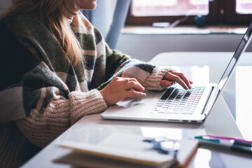 Freelance student girl working at home sitting at table with coffee using laptop, online work and education