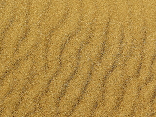 Fototapeta na wymiar Loose sands on the seashore laid out pattern in the form of stripes diagonally, sandy beach, background