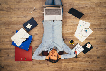 Young man lie on floor in homeoffice relaxed