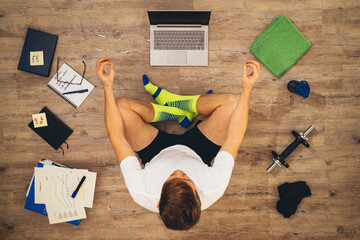 Businessman makes yoga on floor at home