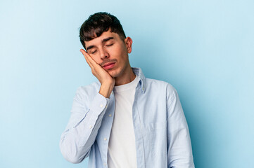 Young mixed race man isolated on blue background who is bored, fatigued and need a relax day.