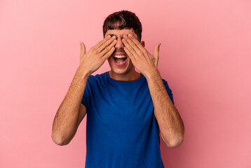 Young mixed race man isolated on pink background covers eyes with hands, smiles broadly waiting for a surprise.