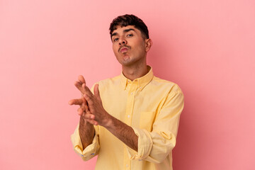 Young mixed race man isolated on pink background feeling energetic and comfortable, rubbing hands confident.