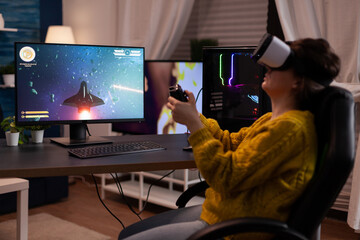 Player woman wearing virtual reality goggles while playing space shooter videogames for online game competition on computer usimg gaming joystick. Streamer player doing entertainment activities