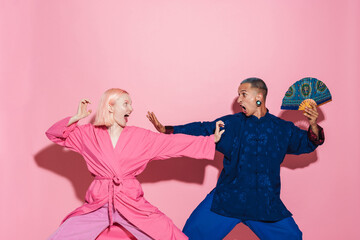 Young white couple in chinese jackets making fun together