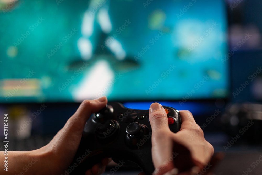 Poster close up of gamer holding controller and playing video games on computer. woman using joystick to pl