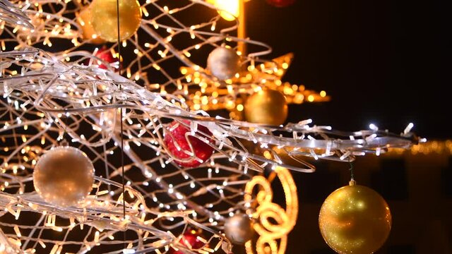 4K video of some beautiful Christmas decorations. Images filmed at a Christmas market with amazing light bulbs next to a tree. Winter holidays.