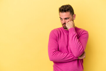 Young caucasian man isolated on yellow background who feels sad and pensive, looking at copy space.