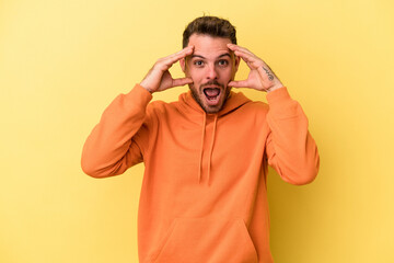Young caucasian man isolated on yellow background receiving a pleasant surprise, excited and...