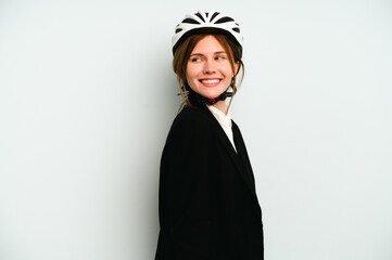 Young business English woman isolated on blue background looks aside smiling, cheerful and pleasant.