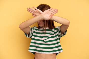 Young English woman isolated on yellow background keeping two arms crossed, denial concept.