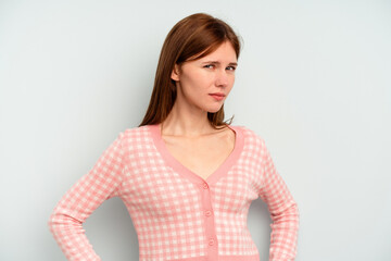 Young English woman isolated on blue background frowning face in displeasure, keeps arms folded.