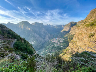 View of a vast valley surrounded by green hills in the light of the setting sun and with a blue sky in the background, Madeira, Portugal