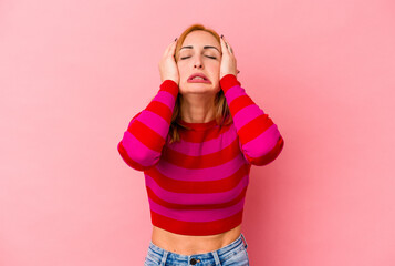 Young caucasian woman isolated on pink background crying, unhappy with something, agony and confusion concept.