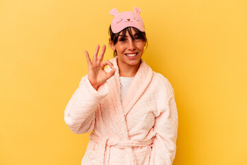 Young Argentinian woman wearing a pajama isolated on yellow background cheerful and confident...