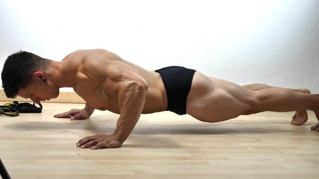 Young man in gym doing push-ups on the floor