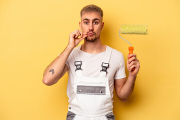 Young painter man isolated on yellow background with fingers on lips keeping a secret.