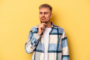 Young caucasian man isolated on yellow background suffers pain in throat due a virus or infection.