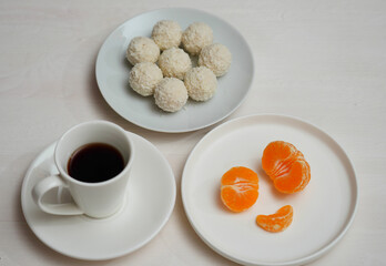 cup of coffee, Raffaello candies  and tangerine