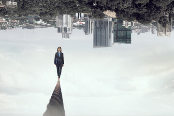 Image of businesswoman balancing on rope. Risk concept