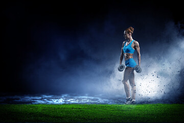 Fototapeta na wymiar Young beautiful girl doing exercise against dark background