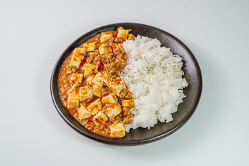 Chinese food mapo tofu dish and rice on black plate