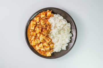 Chinese food mapo tofu dish and rice on black plate