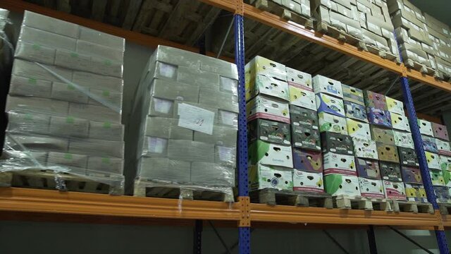 Yerevan, Armenia - September, 2021: Boxes of groceries in a industrial food large cold storage safety refrigerators. Panoramic shot. Slow Motion 