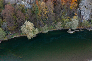 River rapids near mountain foothill with terracotta forests