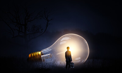 Huge light bulb glowing in the darkness