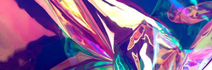 Beautiful holographic background. Defocused wrinkled iridescent foil texture. 80s concept banner.