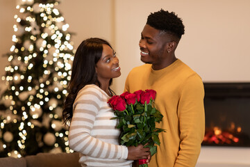 Black Boyfriend Congratulating Wife On New Year Giving Flowers Indoor