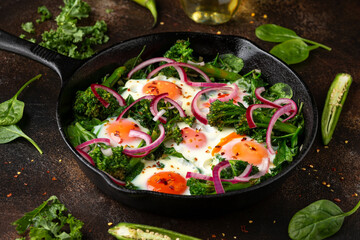 Green shakshuka with golden yolk eggs, kale, spinach and tender broccoli served with pickled onions and chilli flakes