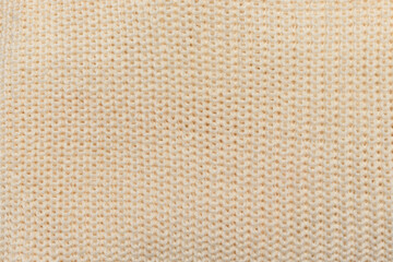 Close-up texture of knitted beige fabric, background for banner, site, postcard, wallpaper.