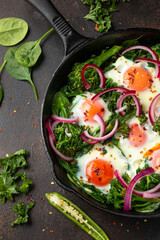 Green shakshuka with golden yolk eggs, kale, spinach and tender broccoli served with pickled onions and chilli flakes