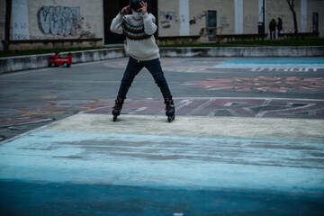 Fototapeta na wymiar Caucasian boy practises roller skating in a city park